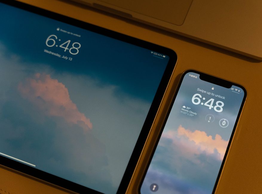 Tablet i smartfon z zablokowanymi ekranami wyświetlającymi tapetę z chmurami