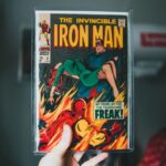 Dłoń trzymająca stary zeszyt komiksu The Invincible Iron Man w ochronnej folii