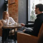 Kobieta i mężczyzna siedzą przy stoliku w kawiarni i rozmawiają