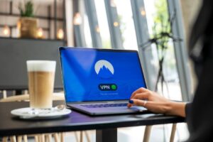 Otwarty laptop z aktywnym połączeniem VPN na ekranie w kawiarni.
